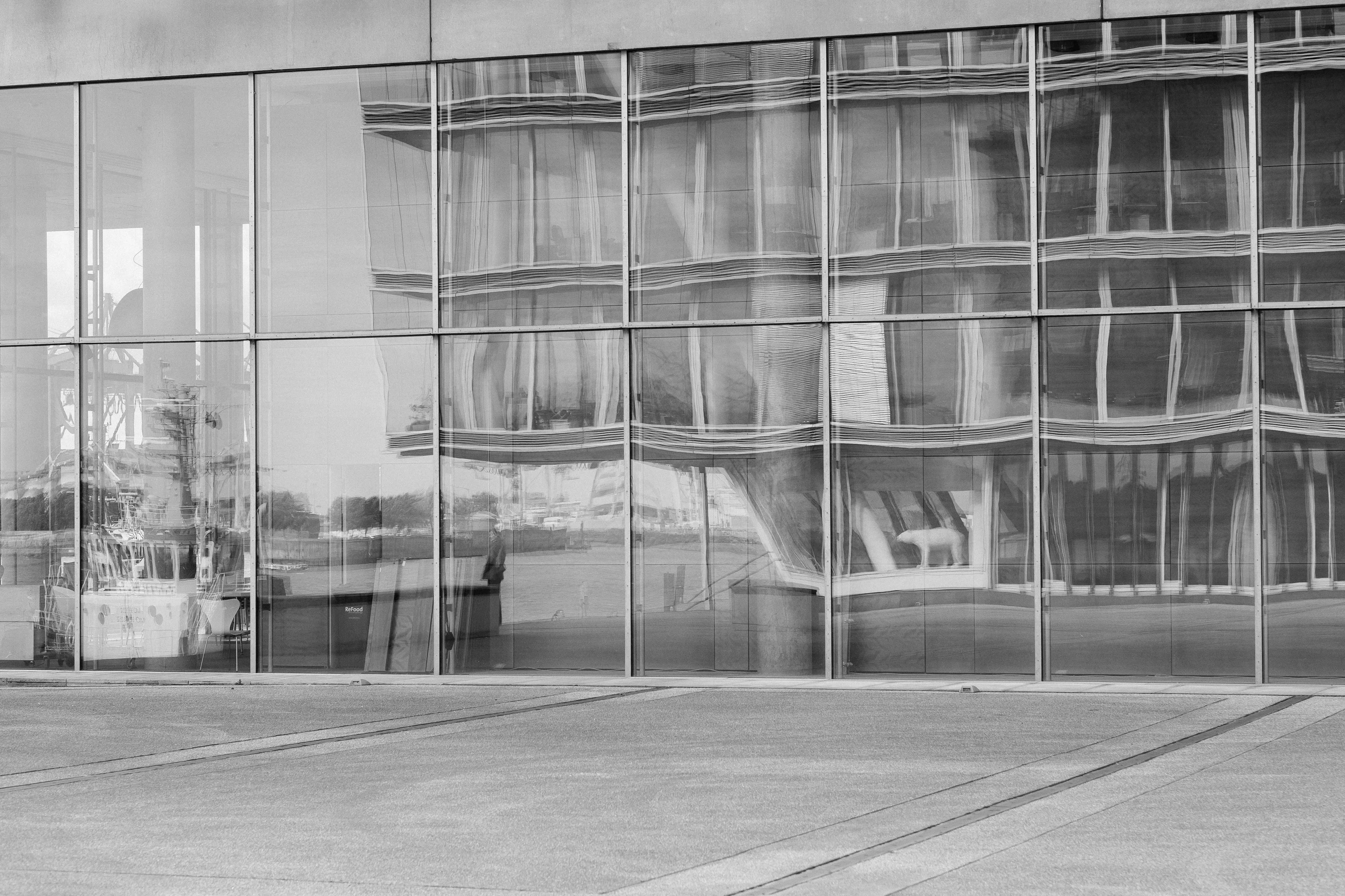 Distorted reflection of a building on glass panels.
