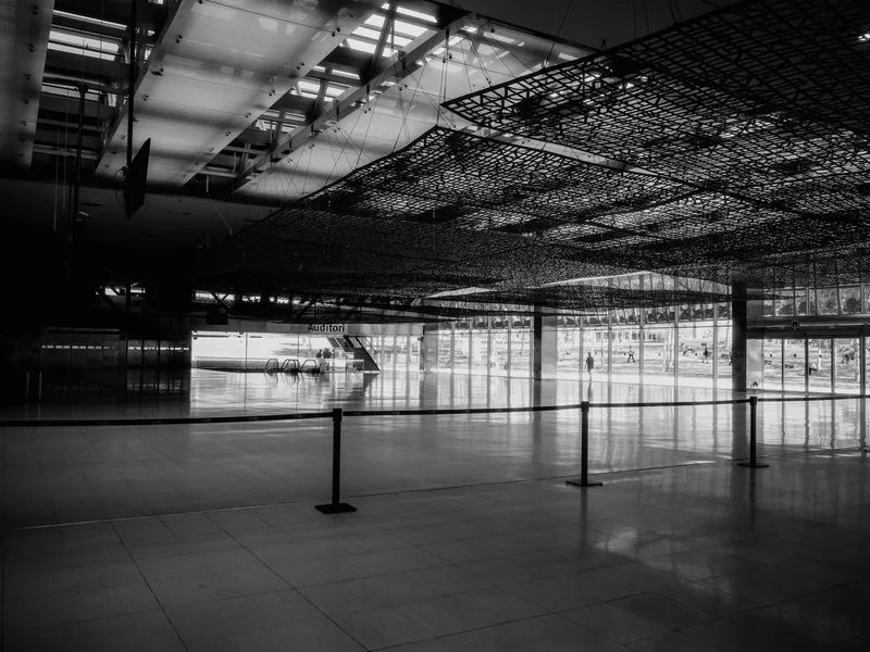 Large indoor space with a spacious lobby, escalators, and a glass exterior wall.